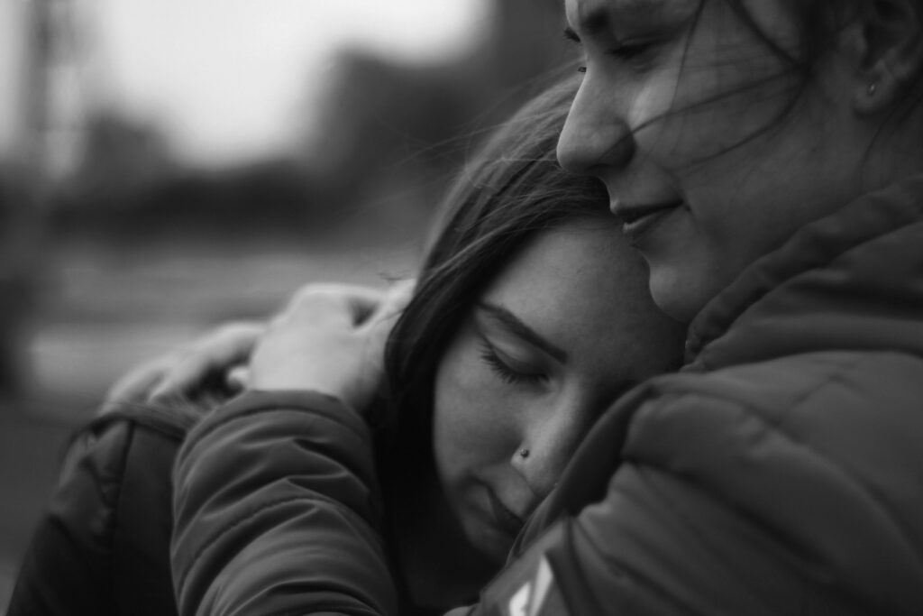 Woman embracing another person, symbolizing emotional healing and recovery from addiction.